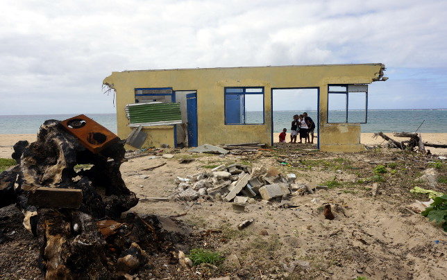 Kids play at the ruins of a house.